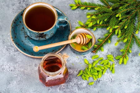 Tannenhonig im Glas neben Tannenzweigen