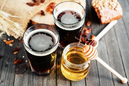 Honigbier Zwei Gläser Honigbier und Honigglas auf Tisch