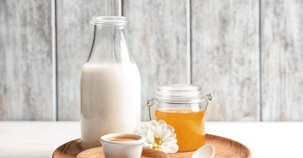 Heiße Milch mit Honig auf Tablett
