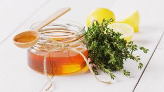 Thymianhonig im Glas auf Tisch