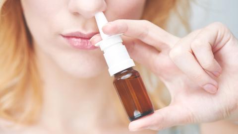 Frau wendet Propolis Nasenspray an