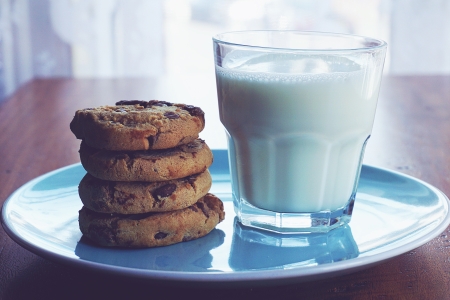 Heiße Milch neben leckeren Schokocookies