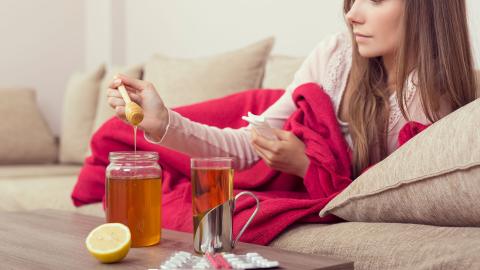 Erkältete Frau verwendet Honig gegen Husten